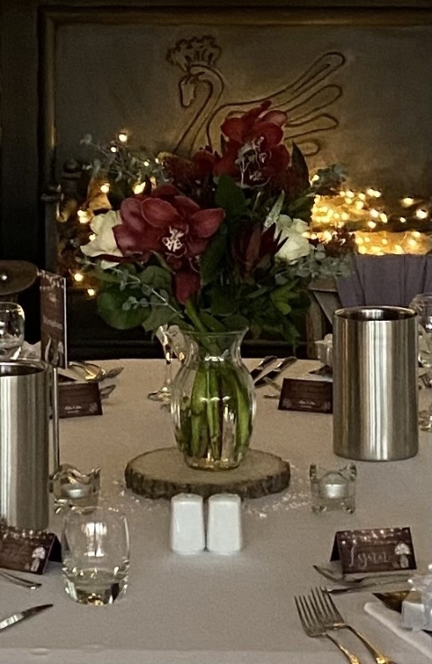 Burgundy Orchids with foliage In Glass Vase